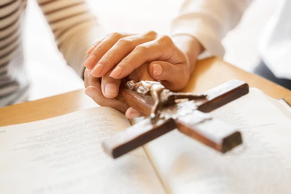 Mujer cristiana orando con las manos juntas en la santa Biblia y la cruz de madera. Mujer rezar para que Dios bendiga a desear tener una vida mejor y creer en la bondad. — Foto de Stock