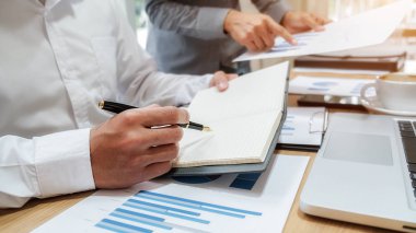 Ekonomik veriler ve rapor grafikleriyle beyin fırtınası yapıp tartışıyorlar. Takım çalışması çalışma konsepti.