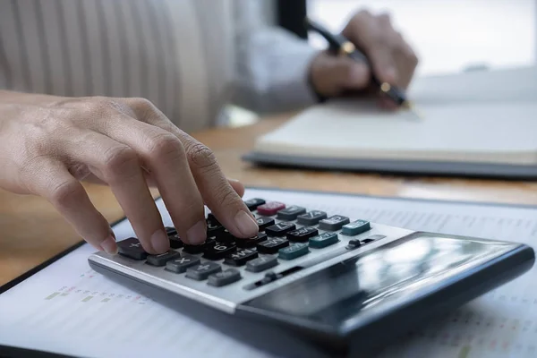 Üzleti adatok számológéppel történő számítása az üzletember kezéről, számviteli dokumentum a székhely szerinti irodában. — Stock Fotó