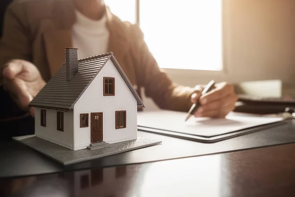 Modello di casa con agente che chiede al cliente un contratto per acquistare, ottenere un'assicurazione o un prestito immobiliare o immobiliare. — Foto Stock