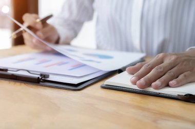 İş kadını başarılı takım çalışmalarının sonuçlarını gösteren çizelge ve grafikleri tartışıyor. İş konsepti.