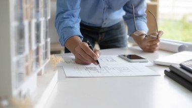 Mühendis ya da mimar, mühendislik aletleri, taslak ve bina modeli ile birlikte çalışıyor. İnşaat konsepti.