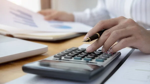 Close-up do homem de negócios mão usando calculadora para calcular os dados de negócios, documento de contabilidade no escritório em casa. — Fotografia de Stock