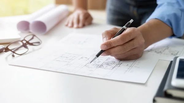 Architect or Engineer working in office with engineering tools, blueprint and building model. Construction concept. — Stock Photo, Image