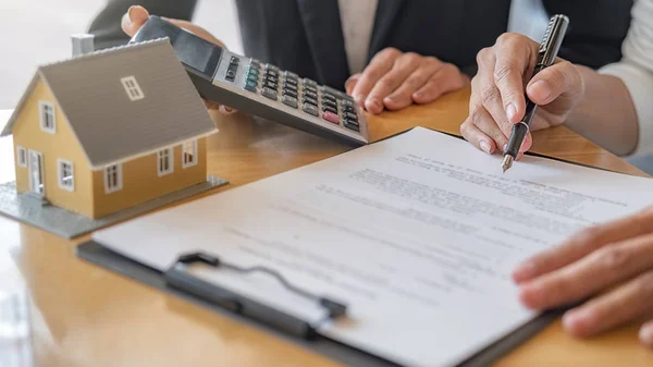 Modelo de casa con agente y cliente discutiendo por contrato para comprar, obtener seguro o préstamo de bienes raíces o propiedad. — Foto de Stock