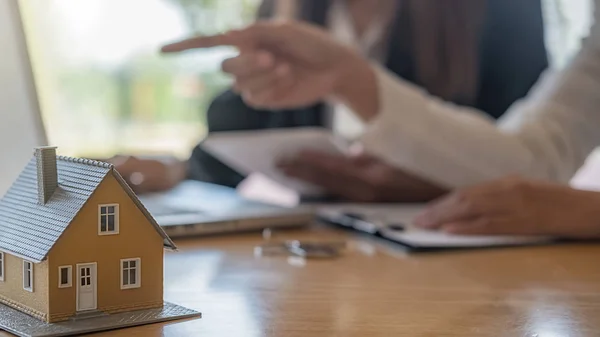 Hausmodell mit Makler und Kunde, die über einen Kaufvertrag, eine Versicherung oder ein Darlehen für Immobilien oder Immobilien diskutieren. — Stockfoto