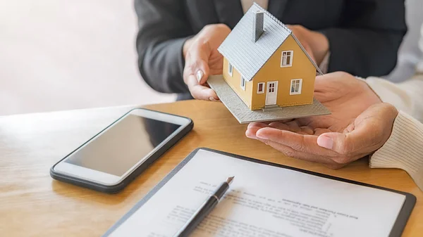 Modelo de casa con agente y cliente discutiendo por contrato para comprar, obtener seguro o préstamo de bienes raíces o propiedad. —  Fotos de Stock