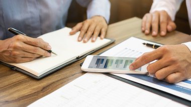 Ekonomik veriler ve rapor grafikleriyle beyin fırtınası yapıp tartışıyorlar. Takım çalışması çalışma konsepti.