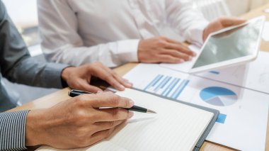 Ekonomik veriler ve rapor grafikleriyle beyin fırtınası yapıp tartışıyorlar. Takım çalışması çalışma konsepti.