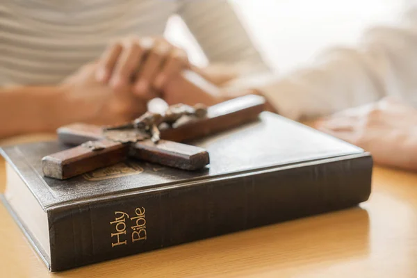 Mujer cristiana orando con las manos juntas en la santa Biblia y la cruz de madera. Mujer rezar para que Dios bendiga a desear tener una vida mejor y creer en la bondad. — Foto de Stock