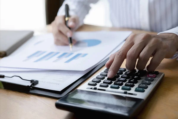 Close-up do homem de negócios mão usando calculadora para calcular os dados de negócios, documento de contabilidade no escritório em casa. — Fotografia de Stock