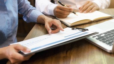 Ekonomik veriler ve rapor grafikleriyle beyin fırtınası yapıp tartışıyorlar. Takım çalışması çalışma konsepti.