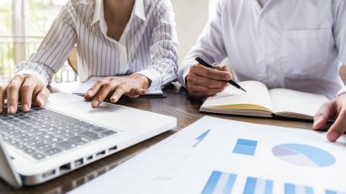 Ekonomik veriler ve rapor grafikleriyle beyin fırtınası yapıp tartışıyorlar. Takım çalışması çalışma konsepti.