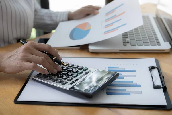 Nahaufnahme von Geschäftsmann Hand mit Taschenrechner zur Berechnung von Geschäftsdaten, Buchhaltungsdokument im Home Office. — Stockfoto