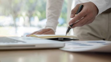 İş adamı başarılı takım çalışmalarının sonuçlarını gösteren çizelge ve grafikleri tartışıyor. İş konsepti.