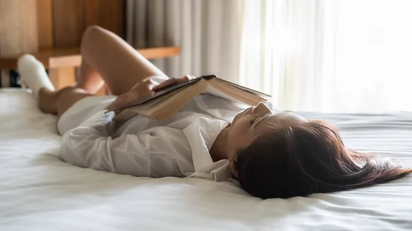 Ázsiai nő pihen, hogy pihenjen az ágyon reggel. Tarts szünetet a hétvégén. Pihentető elv. — Stock Fotó