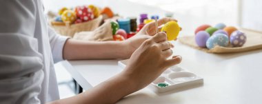 Mutlu Asyalı kadın evde Paskalya için yumurta boyuyor. Aile Paskalya için hazırlanıyor.