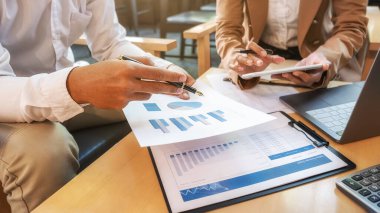 Ekonomik veriler ve rapor grafikleriyle beyin fırtınası yapıp tartışıyorlar. Takım çalışması çalışma konsepti.