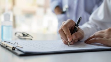 Koronavirüs rapor formunu dolduran Asyalı bir kadın hastanede tavsiye edilen bir doktorla. Tıbbi ve Sağlık Konsepti.