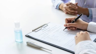 Koronavirüs rapor formunu dolduran Asyalı bir kadın hastanede tavsiye edilen bir doktorla. Tıbbi ve Sağlık Konsepti.