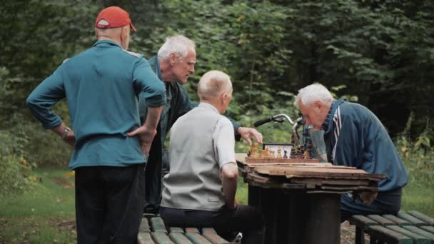 Moskwa, Rosja - 25 lipca 2019: Starzy mężczyźni w parku na ławce do gry w szachy. — Wideo stockowe