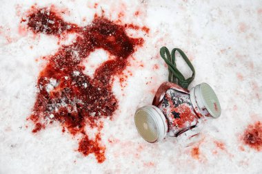 Personal protective equipment gas mask lies in the snow in a puddle of blood clipart