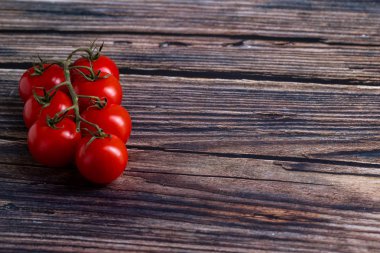 Tahta masadaki kiraz domatesleri.