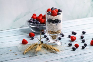 Tahta bir masada böğürtlen ve chia tohumlarıyla müsli.