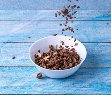 Müsli bir kâseye düştü. Sağlıklı bir kahvaltı için malzemeler.