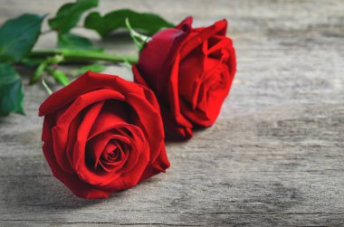 Eski ahşap arka plandaki kırmızı gül buketini kapatır mısın?