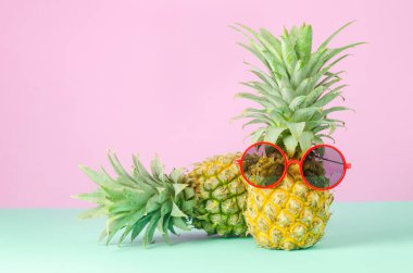 Sarı arka planda kırmızı güneş gözlüklü ananas - yaz arkaplanı