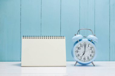 Beyaz ve ahşap arka planda klasik alarmlı boş masa takvimiName