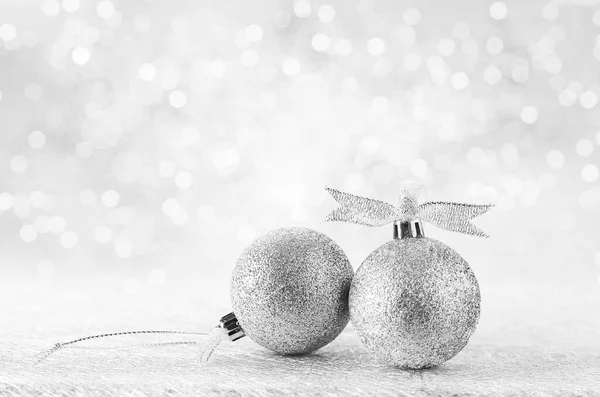 Silver Christmas balls with ribbon on white spakles bokeh light background, Christmas background