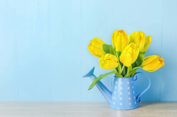 人工的な黄色のチューリップの花青い木の背景に白い水玉模様と缶 — ストック写真