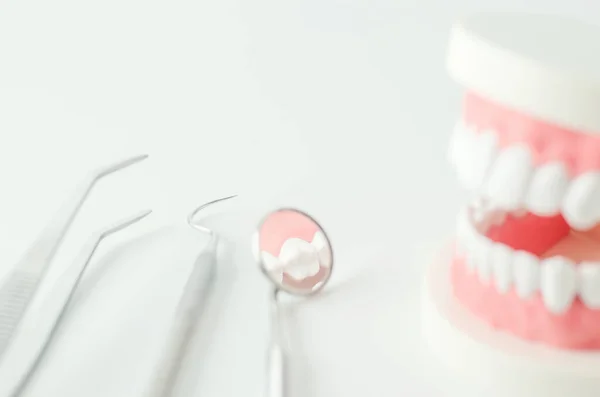 白底牙模和牙科设备的牙镜近视 图库照片