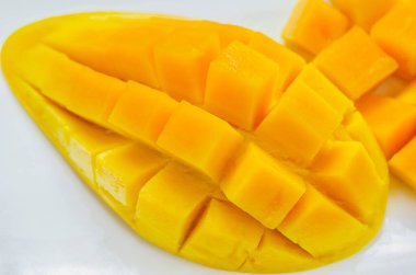 Mangoları beyaz tabakta dilimle, olgun mango meyvesi, tropikal meyve, yaz meyvesi