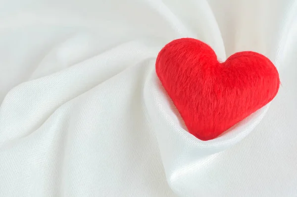 白いサテンのテキスタイルの背景に赤いハート バレンタインと愛のコンセプト — ストック写真