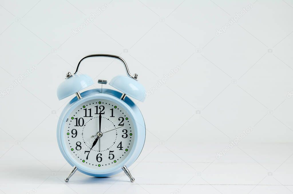 Close up of Blue Vintage Alarm Clock on white wooden table background