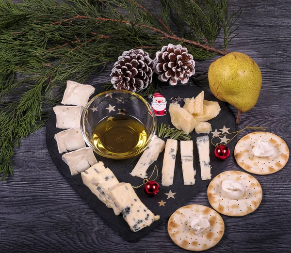 Un plateau de fromage noir avec miel et poire, parmesan, gorgonzola et biscuits . — Photo