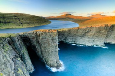 Leitisvatn Gölü ve Tralanipan, günbatımında köle kayası. Vagar Adası, Faroe Adaları. Danimarka