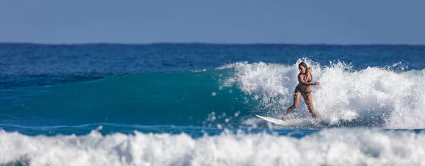 Escuela de surf. Hermosa joven en traje de baño entra en el océano — Foto de Stock