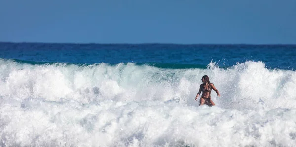 Scuola di surf. Bella giovane donna in costume da bagno va in oceano — Foto Stock