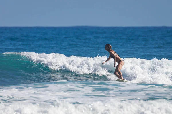 Школа серфинга. Красивая молодая женщина в купальнике уходит в океан — стоковое фото