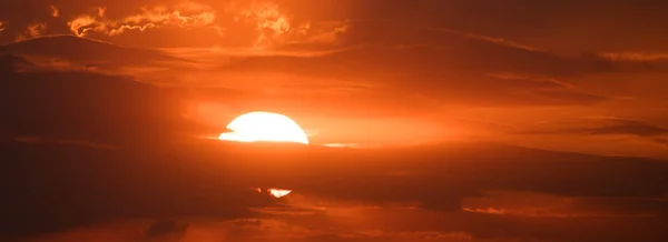 Sonnenuntergang hinter den Wolken, oranger Himmel. schöner Sonnenuntergang — Stockfoto