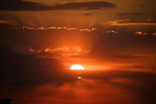 De zonsondergang achter de wolken, oranje hemel. prachtige zonsondergang — Stockfoto