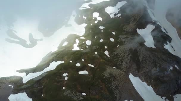 Vliegen over de bergen in de wolken. Luchtfoto van de bergen van de drone. Luchtfoto vliegen over een bergrug van een sneeuwvlaktes. Luchtfoto van de Trail — Stockvideo