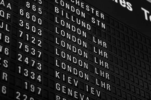 Departures board at the airport. Flight information mechanical timetable. Split flap mechanical departures board. Flight schedule — Stock Photo, Image