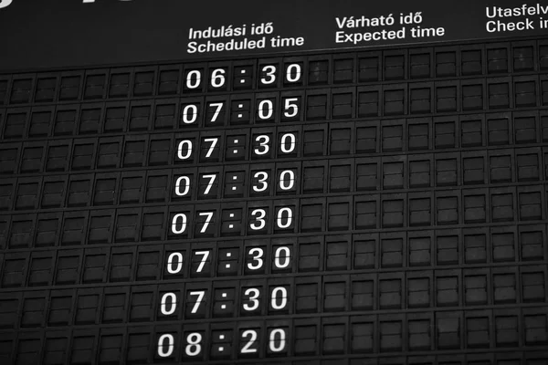 Time boards at the airport. Flight information mechanical timetable. Split flap mechanical departures board. Flight schedule — Stock Photo, Image