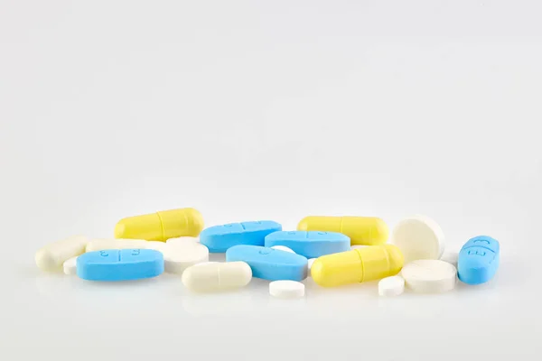 Surtido de píldoras, tabletas y cápsulas de medicamentos farmacéuticos sobre fondo blanco — Foto de Stock