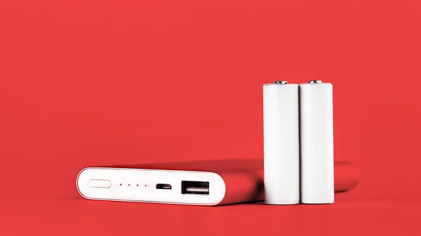 Portable red power bank for charging mobile devices and AA batteries. — Stock Photo, Image